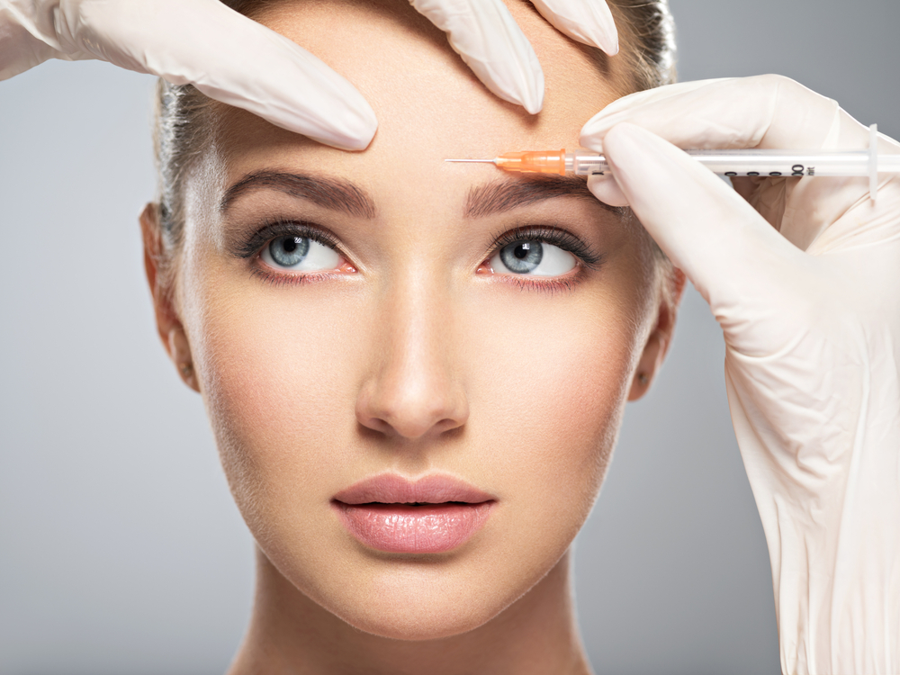 A practitioner preparing a facial aesthetic treatment